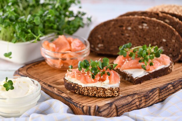 Sandwich ouvert à la crème de fromage sur une tranche de pain de seigle aux céréales tranches de radis saumon