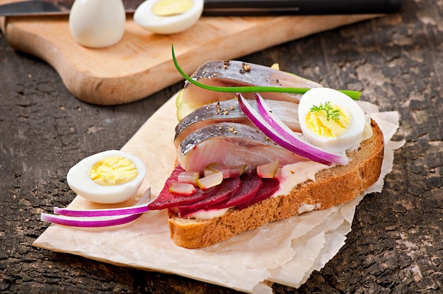 Sandwich de pain de seigle au hareng, betteraves, oignons et oeuf