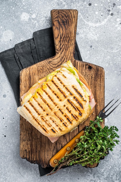 Sandwich Panini grillé avec jambon Prosciutto et fromage Vue de dessus sur fond gris