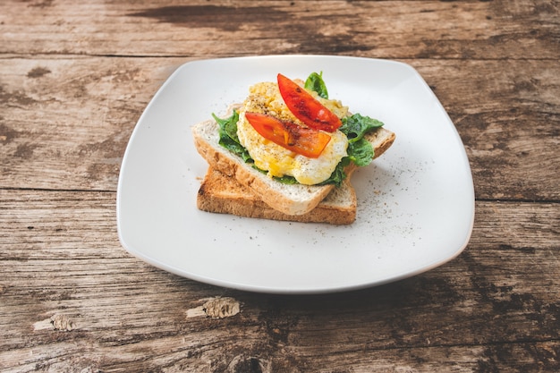 Sandwich petit déjeuner avec oeuf, cresson et tomate sur la table en bois, nourriture saine