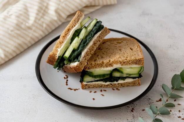 Sandwich sain avec des feuilles de concombre et de chou frisé.