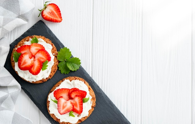 Sandwich sain avec fraise et fromage à la crème sur ardoise Petit-déjeuner savoureux Régime alimentaire propre ou recette facile de sandwich végétarien pour menu végétalien Mise à plat