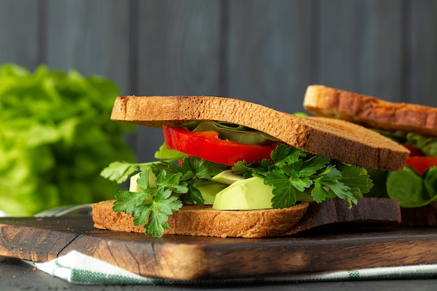 Sandwich sain avec des légumes sur fond de bois foncé