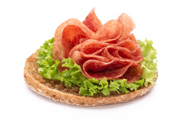 Sandwich avec saucisse au jambon sur un espace blanc.