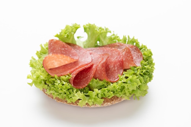 Photo sandwich avec saucisse salami sur fond blanc