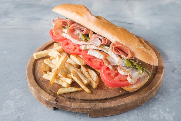 Sandwich Serranito typique d'Andalousie avec jambon, poivre gren et longe de porc grillée