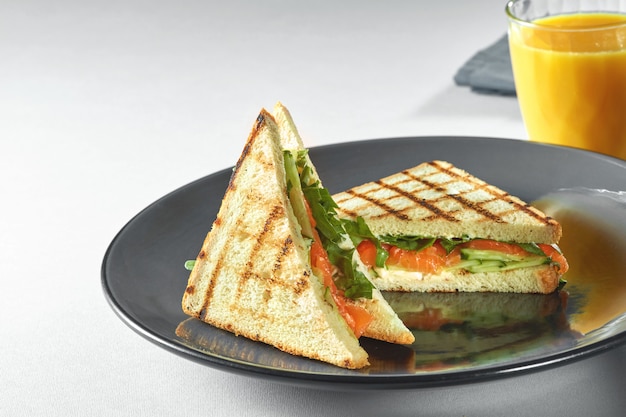 Sandwich Toast Au Saumon, Légumes Et Salade Sur Assiette Et Jus D'orange Frais