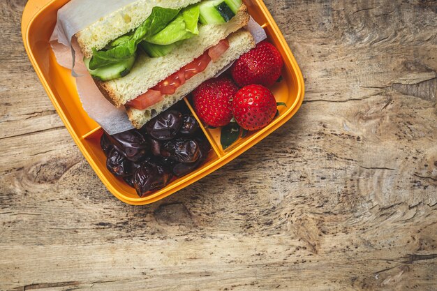 Sandwich végétalien dans un récipient en plastique sur une table en bois. Concept d & # 39; alimentation saine