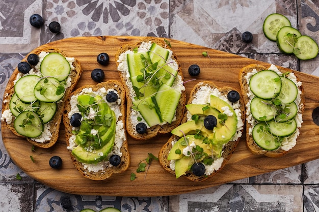 Sandwich végétarien aux micro-verts sur une planche de bois magnifique servant sur un fond clair