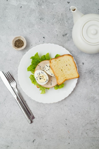 Sandwich avec de la viande de dinde verte et des œufs sur fond gris Nourriture saine