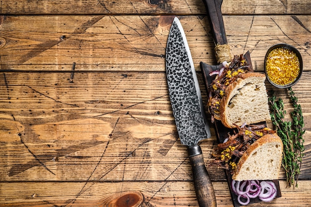 Sandwich à la viande de porc effilochée fumée lentement sur pain blanc. fond en bois. Vue de dessus. Espace de copie.