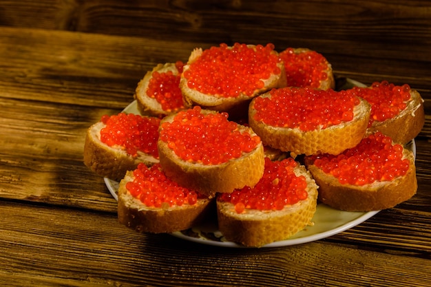 Sandwiches au caviar rouge sur table en bois