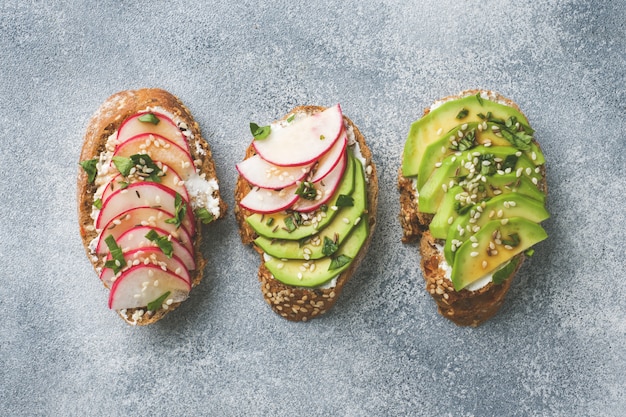 Sandwiches au pain aux céréales avec fromage cottage, avocat frais et radis.