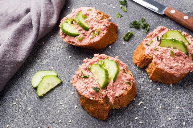 Sandwiches au pâté de poulet et concombre sur tableau noir.