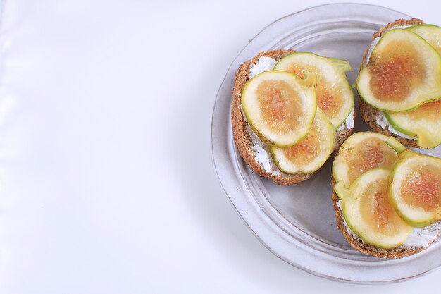 Sandwiches aux figues vertes fraîches canapés Assiette rustique grise Pain complet