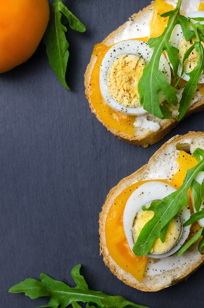 Sandwiches aux œufs durs, tomates jaunes et roquette.