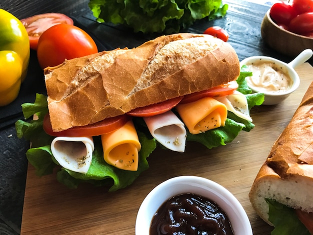 Sandwiches délicieux avec de la dinde, du jambon, du fromage et des tomates