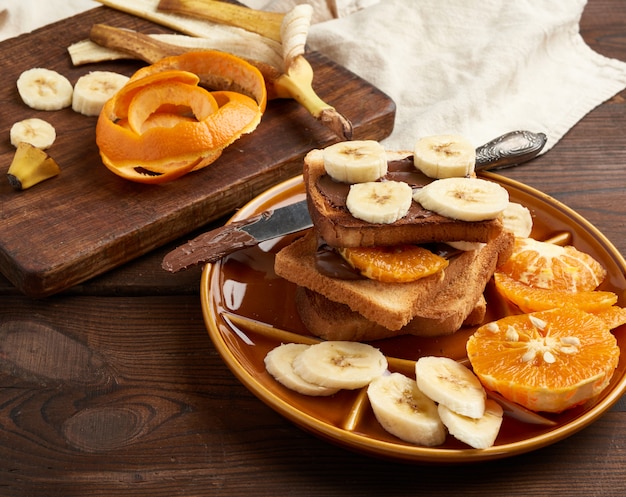 Sandwiches grillés avec pâte de chocolat et tranches de banane sur une assiette, petit déjeuner le matin