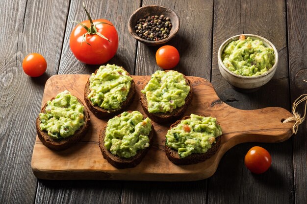 Sandwiches à la sauce guacamole sur une planche à découper sur fond de bois ancien