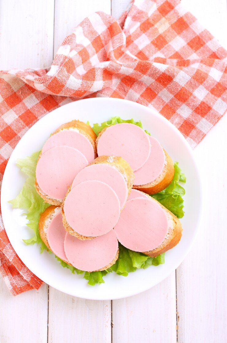 Sandwiches avec des saucisses doctorales dans une assiette blanche sur un fond blanc