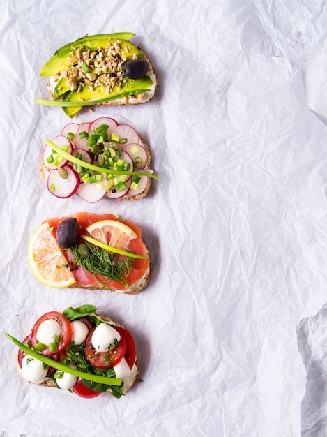 Sandwiches ou tapas avec du pain, du fromage à la crème, des légumes.