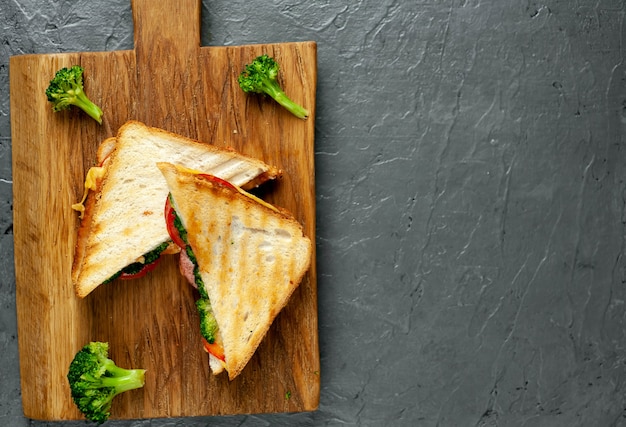 Sandwichs au brocoli sur une planche à découper en bois, sur fond de béton, ardoise