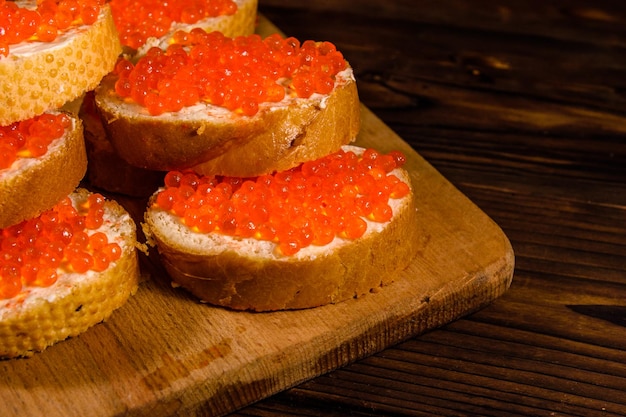 Sandwichs au caviar rouge sur une planche à découper