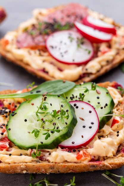 Sandwichs au fromage à la crème, légumes et salami.