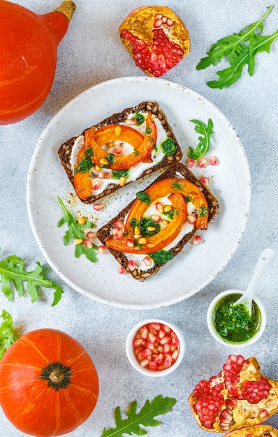 Sandwichs au pain de seigle avec citrouille au four, pesto, roquette, graines de grenade et pignons de pin