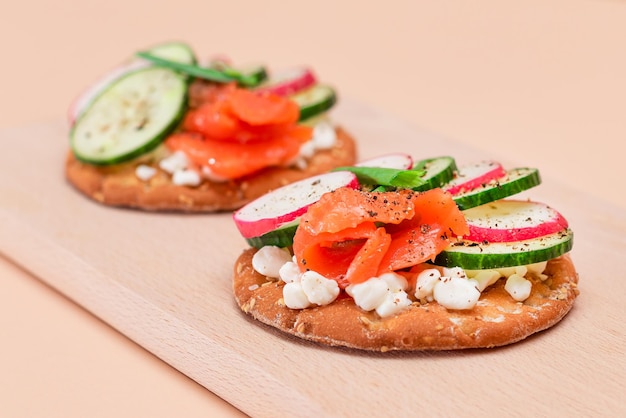 Sandwichs aux craquelins avec saumon, concombre, radis, fromage cottage et oignons verts