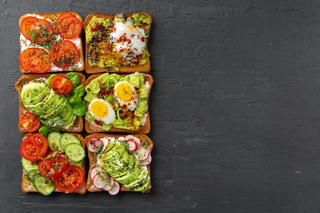 Sandwichs aux légumes sur fond texturé noir