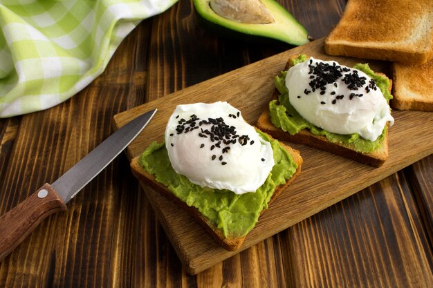 Sandwichs aux œufs pochés et avocat sur la planche à découper