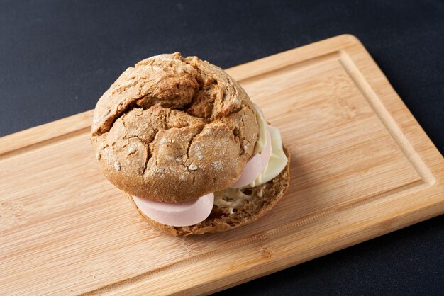 Photo sandwichs aux saucisses et œufs sur une plaque de bois