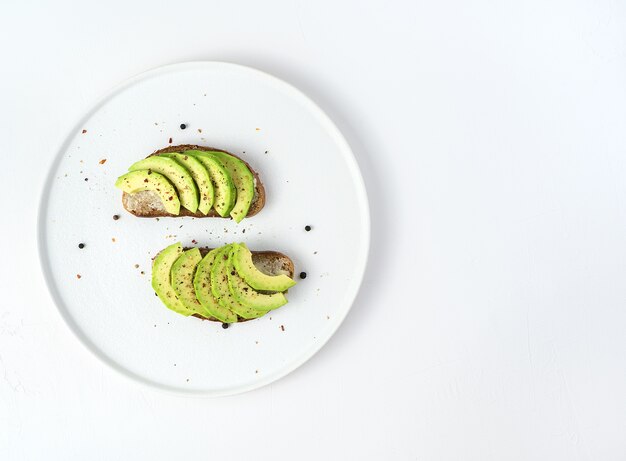 Sandwichs à l'avocat et aux épices sur une plaque blanche