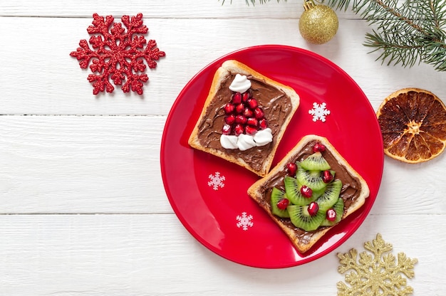 Sandwichs Créatifs En Forme De Sapin De Noël Et De Bonnet De Noel, à Base De Fruits Frais Et De Guimauves. Idée De Petit-déjeuner Amusante Pour Les Enfants. Vue De Dessus