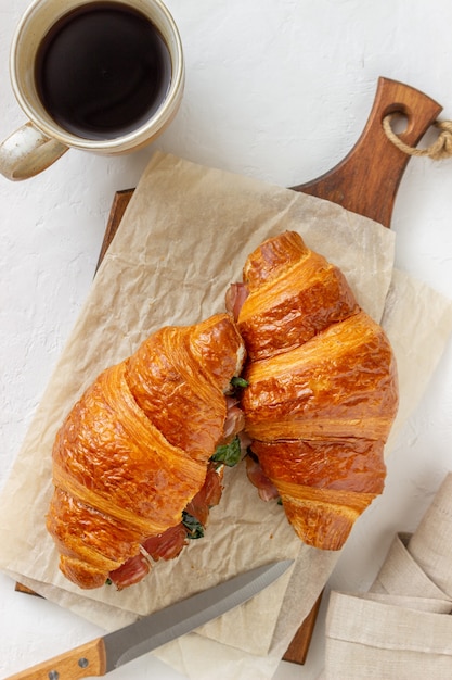 Sandwichs croissants avec prosciutto, basilic et fromage blanc. Cuisine française. Petit déjeuner.