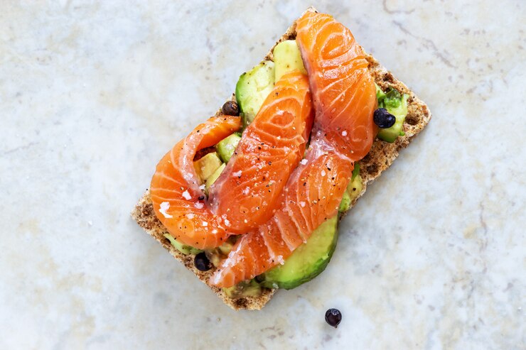 Photo sandwichs croquants à l&#39;avocat et au saumon. fond de marbre.