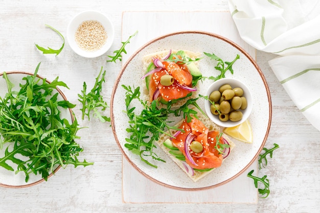 Sandwichs ouverts au saumon salé avocat olives et roquette Petit-déjeuner Vue de dessus