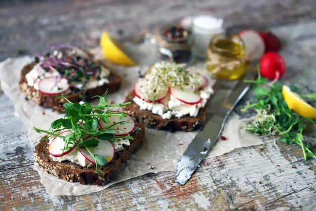 Sandwichs ouverts avec fromage blanc, radis et micro-verts.