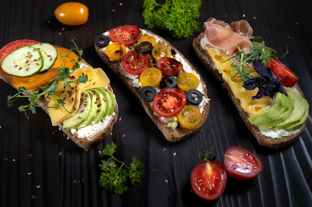 Sandwichs ouverts avec ingrédients légumes avocat tomate cerise et fromage à pâte molle