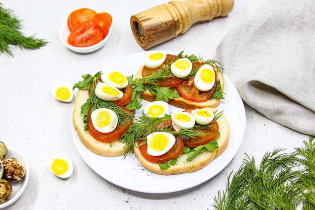 sandwichs de pain grillé frais avec des œufs de caille tomates et herbes vertes vue de dessus en gros plan