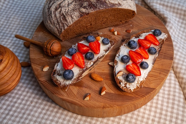 Sandwichs avec pain de seigle maison, miel, fromage et baies