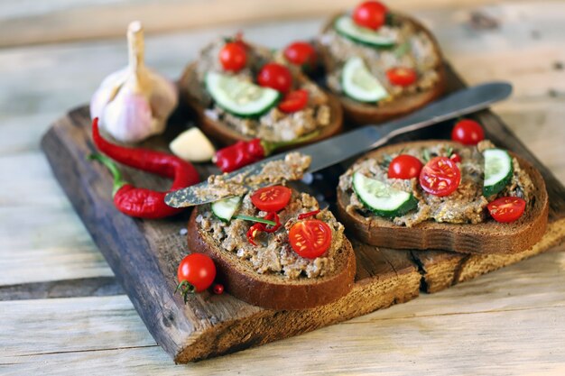 Sandwichs avec pâté sur une planche de bois