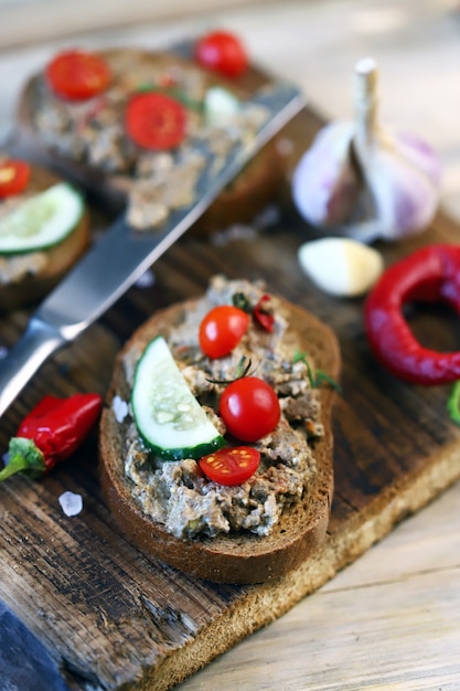 Sandwichs avec pâté sur une planche de bois