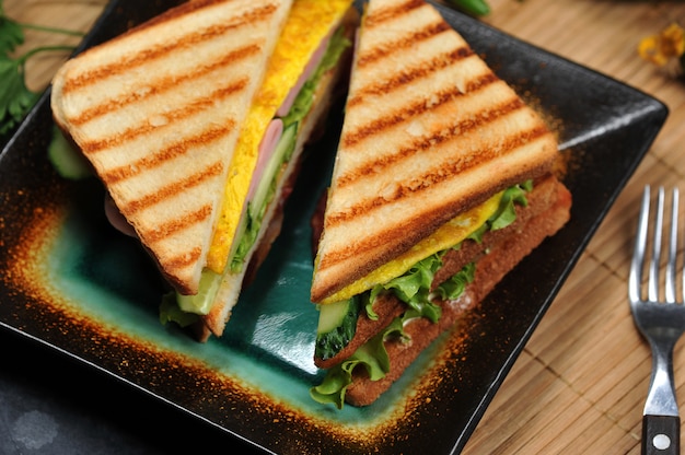 Sandwichs triangulaires avec jambon et omelette sur une assiette