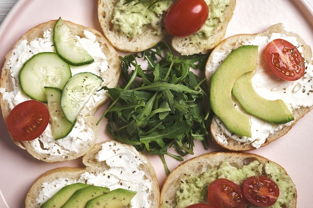 Photo sandwichs végétaliens avec fromage blanc et légumes sur fond de bois.