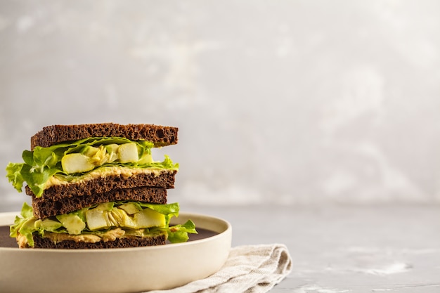 Sandwichs végétaliens verts avec houmous, légumes cuits au four et avocat, espace de copie.