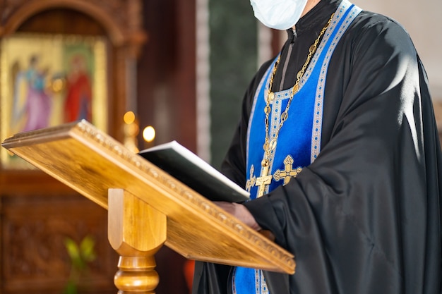 Sans visage. prêtre lit un livre de prières pendant le service au baptême. traditions et rituels religieux. la foi chrétienne