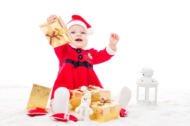 Santa baby girl avec boîte-cadeau et décorations de Noël sur une fourrure