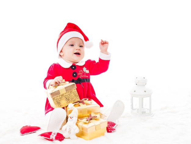 Santa baby girl avec boîte-cadeau et décorations de Noël sur une fourrure